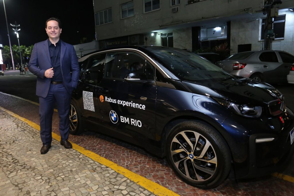 Homem ao lado de um carro preto estacionado